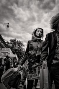 Markedsdag i Brooklyn. Jeg har tænkt meget over, om kvinden er glad, eller om hendes ansigt udtrykker træthed og/eller om hun er opgivende. Manden trækker afsted med hende, og hun slæber på en masse indkøbsposer. Trækker han afsted med hende, fordi der er en konflikt, eller baner han vejen gennem folkemængden for hende?